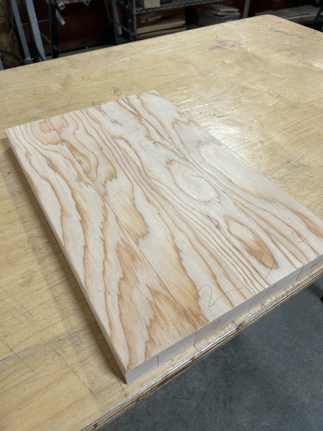 Fig. 1 · The glued hardwood slab, squared and marked, before any shaping — chosen solid so the body resists string tension without flexing out of tolerance.